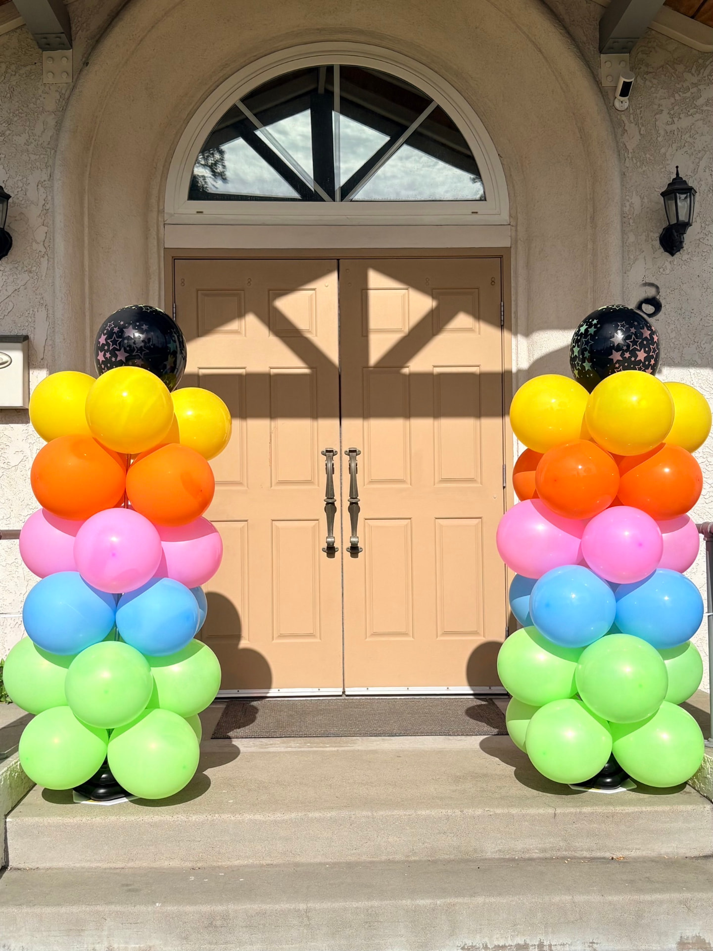 Two colorful balloon columns framing an entrance