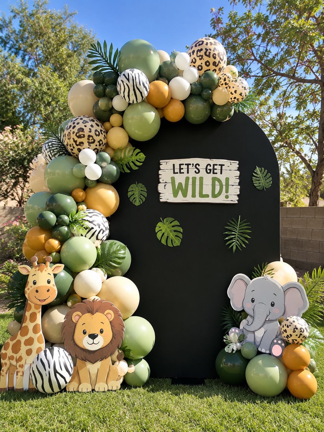 Safari party backdrop with animal cutouts and printed balloons