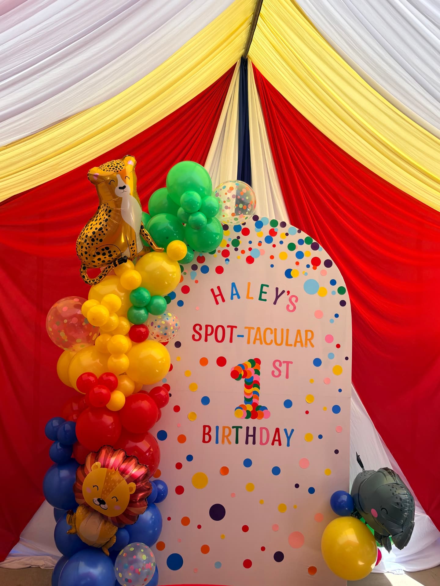 Colorful first birthday circus backdrop with specialty balloons